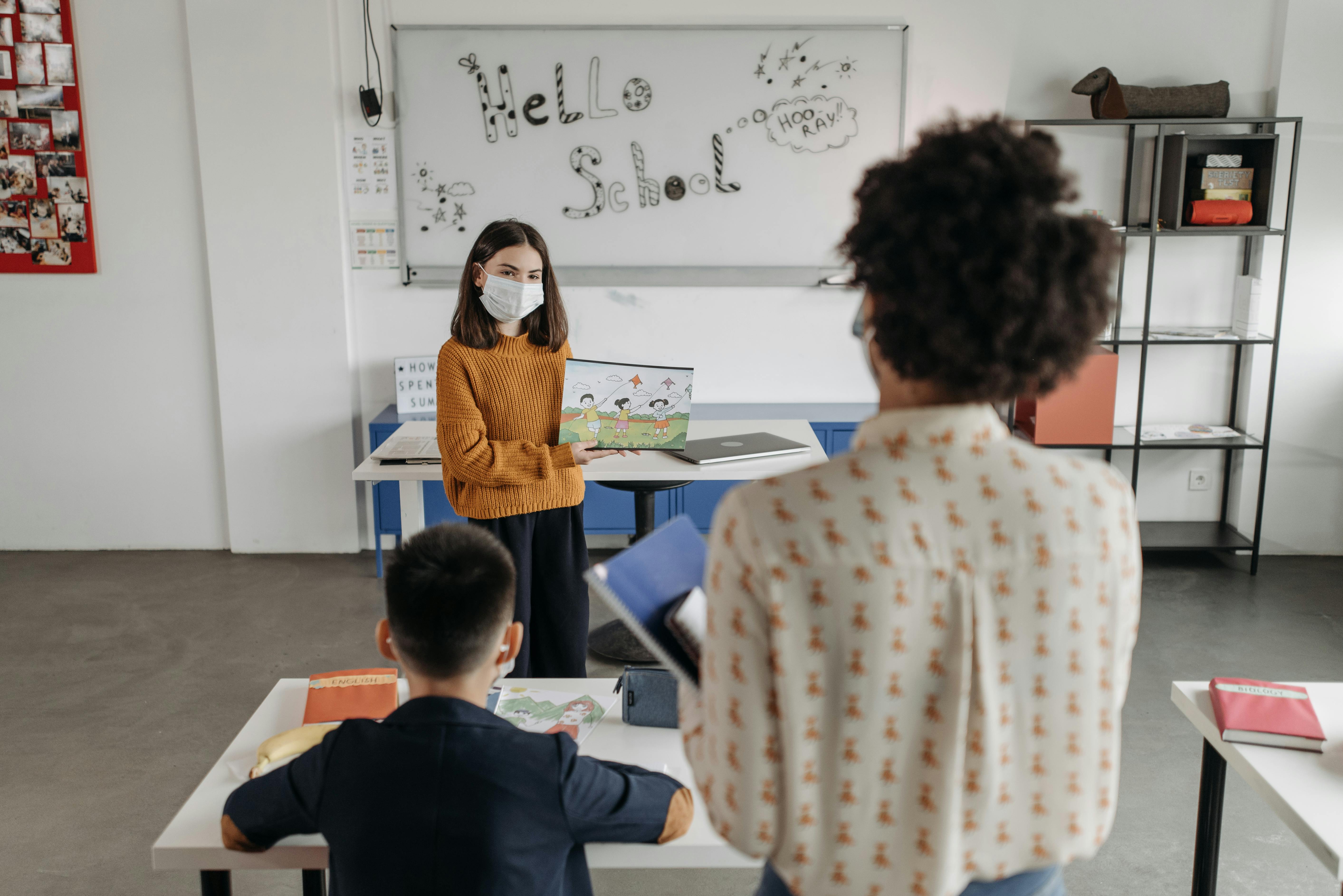 A student giving a presentation at the front of a classroom.